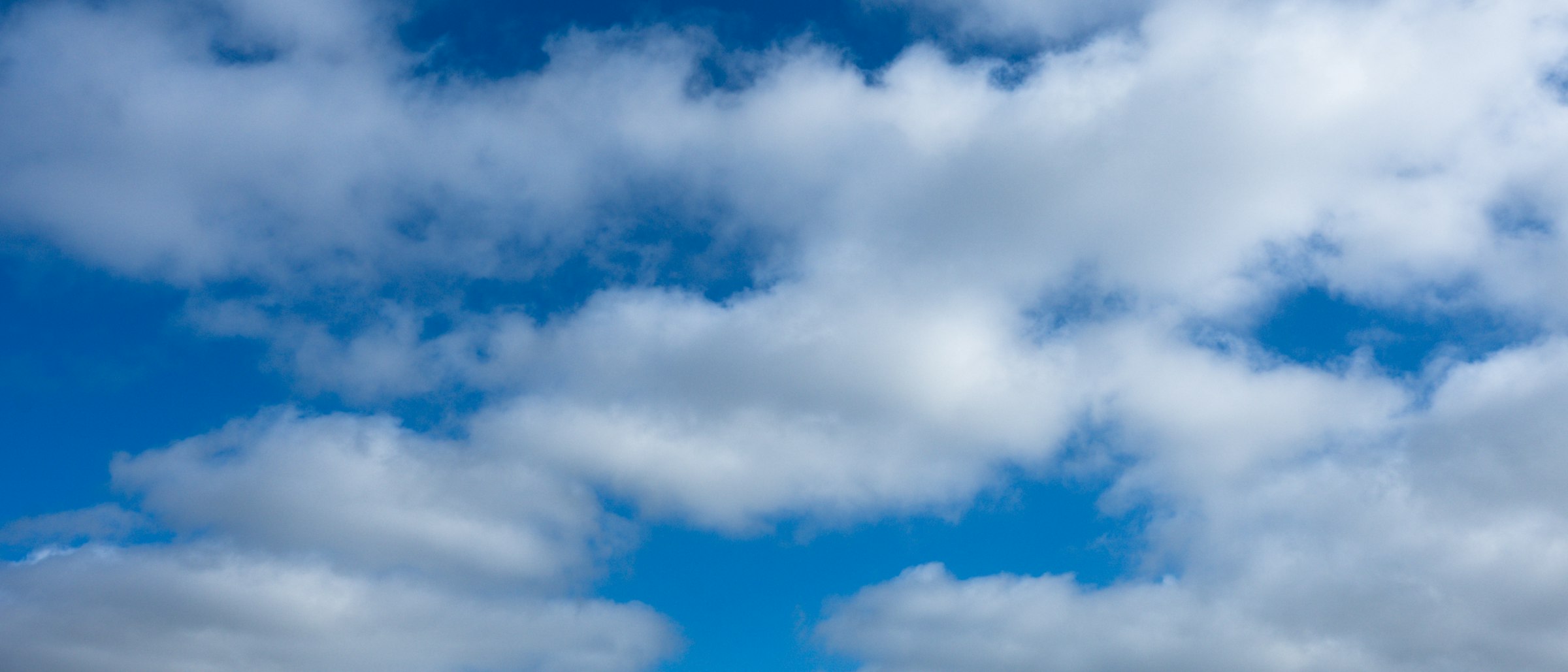 Weiter Sandstrand und Dünen unter einem bewölkten Himmel